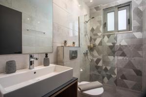 a bathroom with a sink and a toilet and a mirror at Ixia del sol Apartment in Ixia