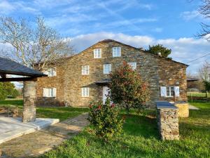an old stone house with a grass yard at Casa Pastur in Serantes