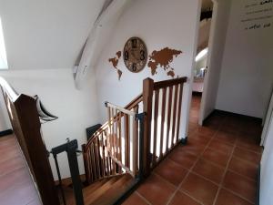 a clock on a wall next to a stairway at L'échanson in Saint-Jean-sur-Mayenne +12 photos