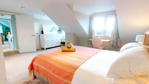 a bedroom with a bed with a teddy bear on it at Croyde Broadlands 5 Bedrooms in Croyde