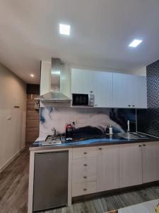 Una cocina con gabinetes blancos y encimera. en Coast Haven 203 Sliema Malta, en Sliema