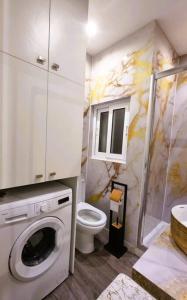 Un baño con lavadora y un inodoro. en Coast Haven 203 Sliema Malta, en Sliema