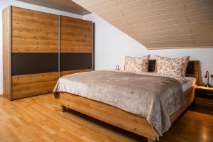 a bedroom with a large bed and a wooden wall at Ferienhaus Pauly in Bergen