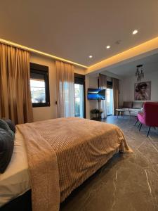 a bedroom with a large bed and a living room at Adas Aura - Boutique Apartments in Old Town Thessaloniki in Thessaloniki