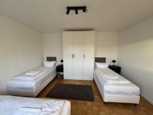 two beds in a room with white walls at Ferienwohnung nähe Montabaur A3 in Großholbach