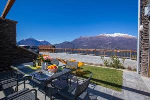 a table and chairs on a patio with a view of mountains at house with 3 bedrooms T5 in Bellano