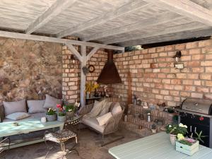 a patio with a couch and a table and a brick wall at Vila Anna in Želízy