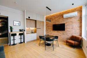 a living room with a table and chairs and a brick wall at G Residence in Athens