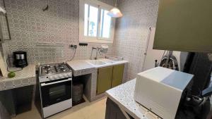 a small kitchen with a stove and a sink at Petit appartement vintage in Dakar