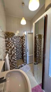 a bathroom with a shower and a tub and a sink at Petit appartement vintage in Dakar +10 photos