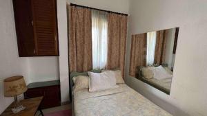 a bedroom with a bed with a large mirror at Petit appartement vintage in Dakar