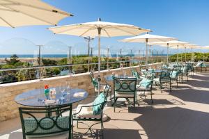 a row of tables and chairs with umbrellas at Hotel Quinta do Lago in Quinta do Lago
