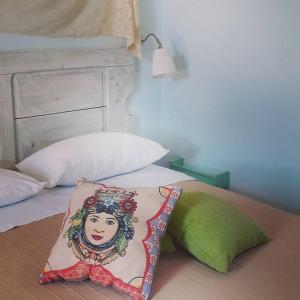 a bed with a pillow with a woman on it at Sottovento Marzamemi Rooms&Relax in Marzamemi
