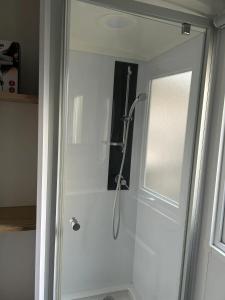 a shower with a glass door in a bathroom at Bungalow confortable à Saint-Brevin-les-Pins avec piscine, 40 m² in Saint-Brevin-les-Pins +9 photos