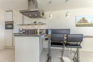 een keuken met een aanrecht en 2 stoelen. bij Appartement Luk in Westerland +10 foto's