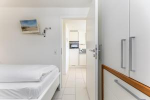 een slaapkamer met een bed en een deur naar een keuken bij Appartement Luk in Westerland