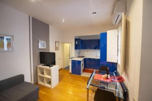 a kitchen with blue cabinets and a living room at Cozy 2BR Apartment near Piazza Navona in Rome