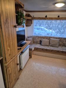 a living room with a couch in an rv at Mobil-Home N 17 in Fourmies +85 photos