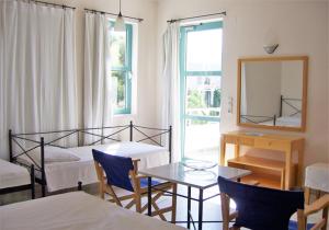 a bedroom with a bed and a table and a mirror at Hotel Plakures in Falasarna