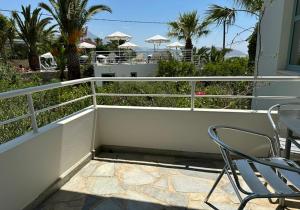 a balcony with two chairs and a table and chairs at Hotel Plakures in Falasarna