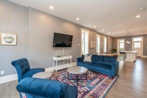 a living room with blue furniture and a flat screen tv at 4154 Parkside Comfort in Tower Grove