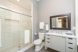 a bathroom with a toilet and a shower and a sink at 4154 Parkside Comfort in Tower Grove +17 photos