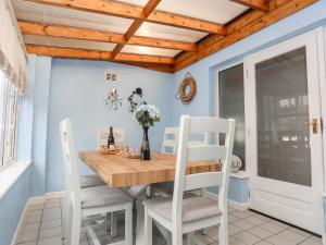 a dining room with a wooden table and chairs at Rhedyn in Pwllheli