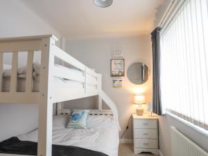 a bedroom with a bunk bed with a white bunk bed at Rhedyn in Pwllheli