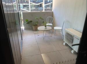 a balcony with a table and chairs and a window at 2BR-2BR-1Car-CBD-Pool-Shopping in Canberra