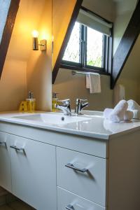 a bathroom with a white sink and a window at Camelot Motor Lodge in Christchurch