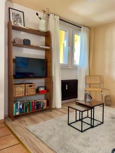 a living room with a tv and a table at Urlaub in der Eifel direkt am Rursee - Seeblick in Simmerath