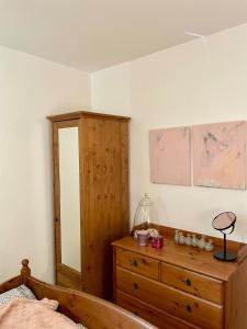 a bedroom with a bed and a dresser and a cabinet at Urlaub in der Eifel direkt am Rursee - Seeblick in Simmerath +5 photos