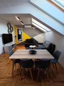 a living room with a table and chairs and a couch at SND Aparts in Novi Sad