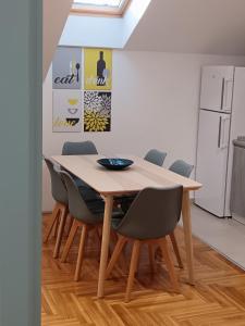 a dining room with a wooden table and chairs at SND Aparts in Novi Sad