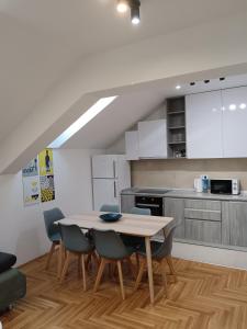 a kitchen with a table and chairs in a room at SND Aparts in Novi Sad