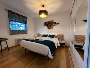 a bedroom with a large bed and a window at Garogwen by Madame est Servie in Pleumeur-Bodou
