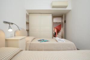 two beds in a small room with two beds sidx sidx sidx at La Rosa Del Mare in La Maddalena +6 photos
