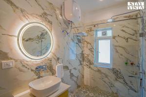a bathroom with a shower and a toilet and a mirror at StayVista at Pineview @ Albert Estate in Mussoorie +48 photos