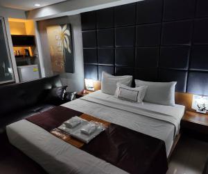 a bedroom with a large bed and a couch at Collection O The Bangkok Cha Cha Suite in Bangkok +30 photos