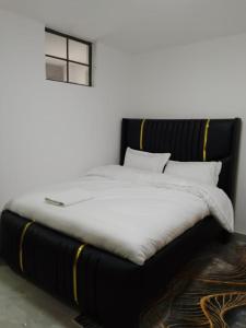 a bed with white sheets and a window in a room at Haven Studio in Nairobi