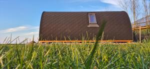 a small house with a roof with a window at Boerderij Camping NixHoeve in Genderen