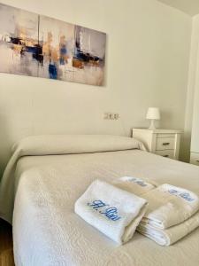 a bedroom with a bed with two towels on it at Hostal Rios in Bolonia