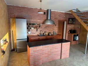 a kitchen with a brick wall and a refrigerator at D&R Apartments in Mažeikiai