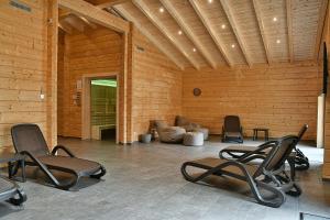 ein Zimmer mit Stühlen und einer Couch in einem Holzzimmer in der Unterkunft Feriendorf Blauvogel Blauvogel 052 in Hasselfelde