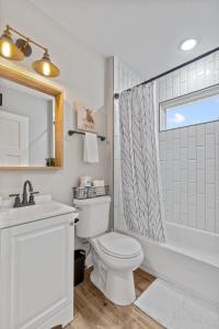 a bathroom with a toilet and a sink and a shower at 4456 Blue Door Bungalow in Southhampton +20 photos