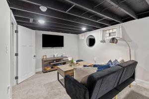 a living room with a couch and a tv at 4456 Blue Door Bungalow in Southhampton