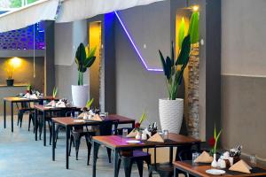 a row of tables in a restaurant with plants at Hillside Hotel in Mysore
