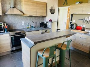 a kitchen with two green chairs at a counter at Appartement T3 - Côté Lac - Les appartements de Lucie à Allinges in Allinges