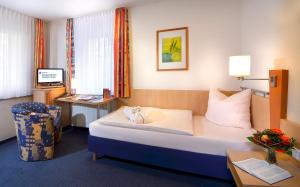 a hotel room with a bed and a desk at Tagungszentrum Neuendettelsau in Neuendettelsau