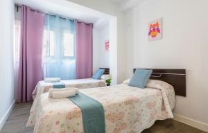 2 Betten in einem Zimmer mit lila Vorhängen in der Unterkunft Apartments Vistas Mar Bahia in Cádiz + 45 Fotos